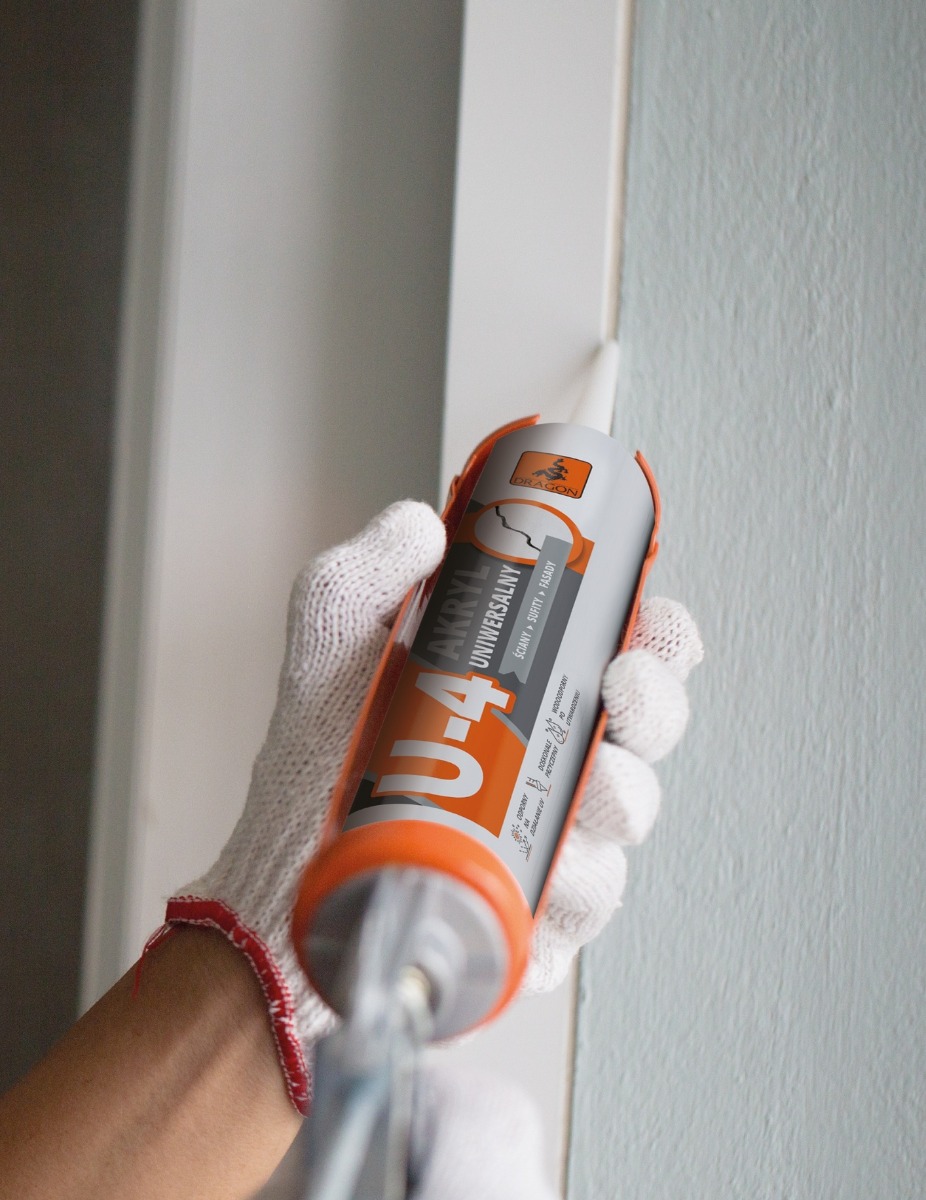 Nakładanie silikonu na szczelinę między ramą okna a ścianą przy pomocy pistoletu